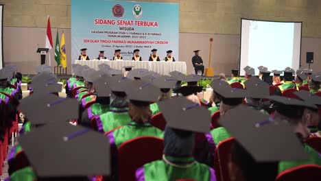 University-Dean-and-board-of-officials-giving-speech-at-final-diploma-graduation-ceremony,-graduation-caps-during-commencement