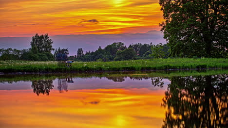 Symmetry-in-lake-reflection-of-the-amazing-orange-sky-and-rural-area