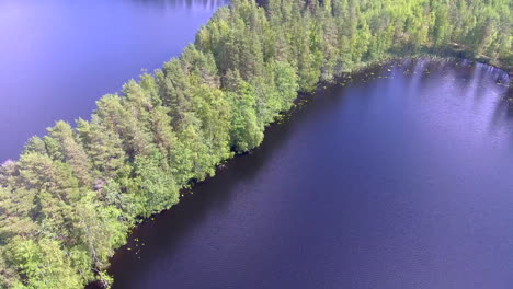 Hermoso-Video-De-Drones-De-Una-Pequeña-Capa-En-Un-Impresionante-Lago-Forestal-Finlandés