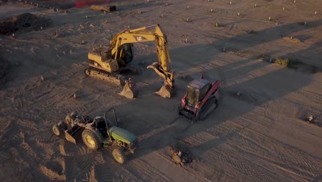 Drone-circling-around-a-parked-construction-vehicle-in-empty-field