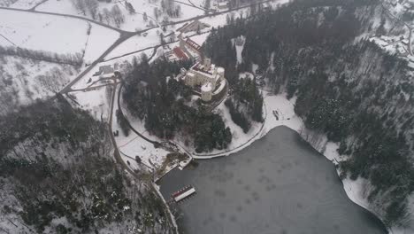 Aerial-view-of-frozen-lake-and-fairy-tale-castle-in-the-distance-at-winter