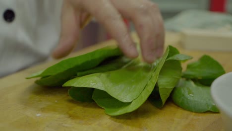 Commercial-kitchen,-chef-cutting-leafy-bok-choi-lettuce