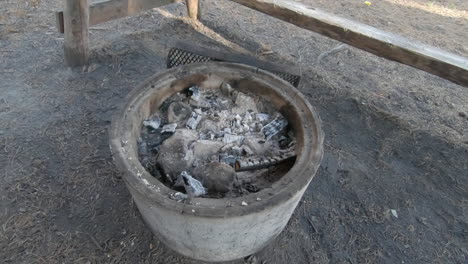 Warm-charcoal-left-in-an-empty-windbreak-after-preparing-food