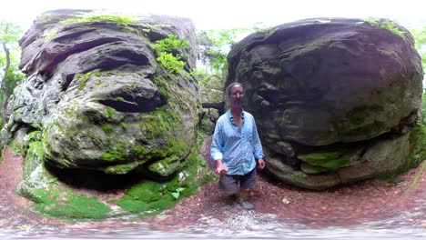 360-vr-of-mature-man-walking-through-a-slot-in-large-boulders
