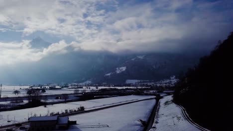Drohnenaufnahme-über-Einer-Winterlandschaft-Mit-Autos-Und-Einem-Zug-In-Der-Schweiz