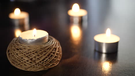 Lighting-a-small-decorative-tealight-candle-with-many-more-flames-dancing-in-the-background