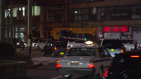 Toma-Estática-Del-Tráfico-Nocturno-Con-Autos-Y-Taxis-En-La-Ciudad-Japonesa