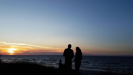 Junges-Paar-Beobachtet-Den-Sonnenuntergang-Am-Strand