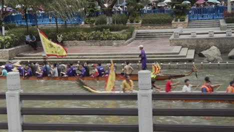 Chinese-people-paddle-and-hit-drums-on-a-dragon-boats-during-dragon-boat-festival-in-downtown-of-Guangzhou,-Guangdong,-China