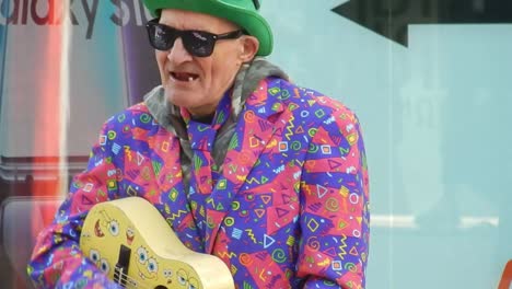 Colourful-Liverpool-city-street-busker-playing-toy-guitar---singing-badly