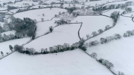 Schneebedeckte-Englische-Felder-Mit-Einem-Quad-Geländefahrzeug,-Das-Um-Den-Rand-Eines-Feldes-Rast
