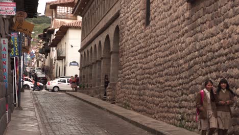 Calle-Vacía-En-Cusco-Con-Dos-Niñas-De-La-Escuela-Caminando-Y-Riendo,-Perú