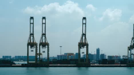 Teleaufnahme-Der-Hafenkräne-Von-Singapur-Vom-Meer-Aus-An-Einem-Sonnigen-Tag