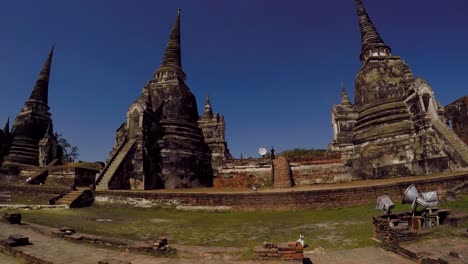 Tourists-walking-around-temples-in-old-city-of-Ayutthaya,-Thailand