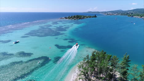 AERIAL:-Slow-motion-boat-on-tropical-island