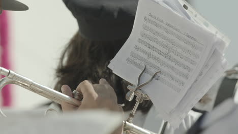 Musician-playing-music-in-the-philharmonic-orchestra-with-other-musicians-looking-to-a-musical-sheet-in-front-of-a-church