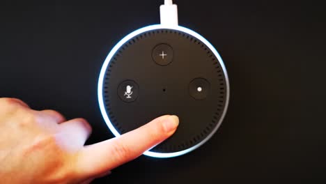 Niña-Presionando-El-Botón-Para-Bajar-El-Volumen-En-El-Dispositivo-De-Inteligencia-Artificial-Alexa