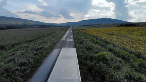 Road-and-car-traffic-surrounded-by-agricultural-land---aerial-shot