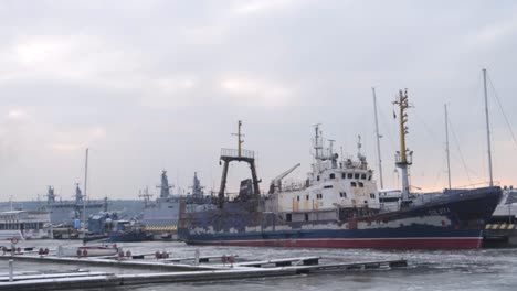 Tall-boats-stuck-in-frozen-port-during-winter-with-ice-cold-weather-on-overcast-day