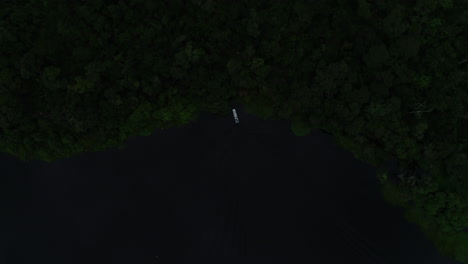 aerial-video-of-a-boat-sailing-towards-the-forest-and-entering-it