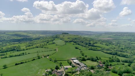 Picturesque-aerial-of-solitary-countryside-hill-in-the-rolling-Devon-landscape