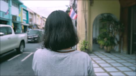 Vista-De-La-Parte-Posterior-De-Una-Mujer-Joven-Mientras-Camina-En-El-área-Local-Del-Casco-Antiguo-En-Phuket,-Tailandia