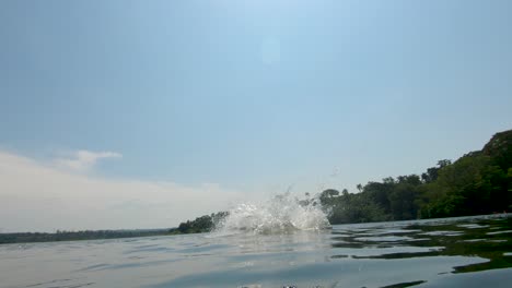 A-young-African-boy-swings-on-a-rope-swing-and-does-a-back-flip-into-the-river-Nile-in-Uganda