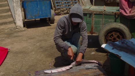 Lokaler-Marokkanischer-Fischer,-Der-Frischen-Fisch-Auf-Dem-Markt-In-Essaouira-Schneidet