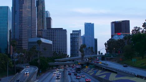 Kippender-Zeitraffer-Des-Autobahnverkehrs-Und-Der-Innenstadt-Von-Los-Angeles-In-Der-Abenddämmerung-Mit-Lichtspuren