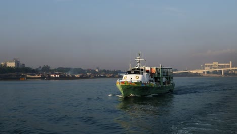 Small-ferry-passes-the-Marcelo-Fernan-Bridge-connecting-Mactan-and-Cebu-islands-as-it-traverses-the-Mactan-Channel,-Philippines