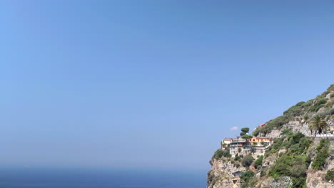 Locked-Off-View-Of-Cliff-Side-Next-To-Expanse-Of-Blue-Sky-And-Ocean-In-Amalfi-Coast,-Italy