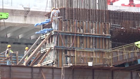 Bauarbeiter,-Die-In-Der-Höhe-Arbeiten,-Installieren-Bewehrungsstäbe-Und-Schalungsarbeiten-Auf-Der-Baustelle