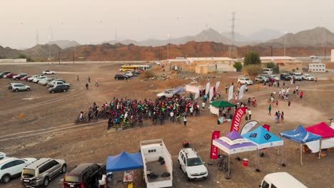 Filipino-mountain-bikers-at-the-starting-line-of-a-cycling-race-event-in-a-barren-area-with-mountains---AERIAL-SHOT