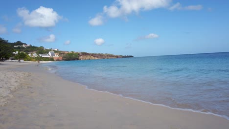 A-couple-walking-along-Grand-Anse-Beach-back-to-the-resort-on-the-Caribbean-island-of-Grenada