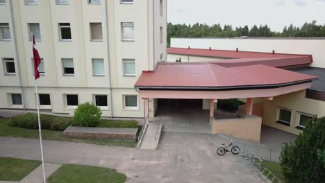 Fast-flyaway-from-highschool-entrance-to-aerial-view-of-building---revealing-playground-next-to-it