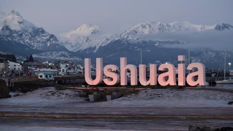 Totale-Beleuchtetes-Ushuaia-Schild-Und-Berge-Im-Hintergrund-Bei-Nacht