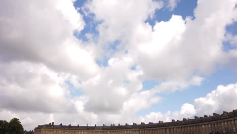 Der-Königliche-Halbmond-In-Bath,-Somerset,-Der-An-Einem-Sommertag-Vom-Blauen-Himmel-Mit-Weißen-Wolken-Hereinschwenkt