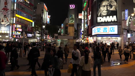 Zeitlupenaufnahme-Einer-Großen-Menschenmenge,-Die-Nachts-über-Den-Shibuya-Kreuzung-Geht,-Japan