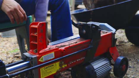 Man-using-log-splitting-machine-on-log-multiple-times-successfully