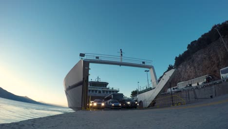 Ferryboat-arriving-to-a-shore,-time-lapse,-disembarking-and-embarking-cars-and-people-in-the-evening