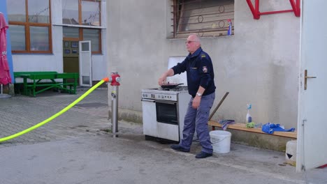 Feuerwehrmann-Demonstriert-Sicheres-Löschen-Eines-Feuers-In-Der-Küche