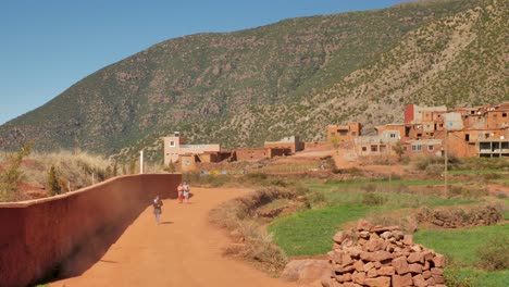 Kinder-Im-Bergdorf-High-Atlas-In-Marokko-Gehen-Auf-Der-Roten-Unbefestigten-Dorfstraße-Zur-Schule