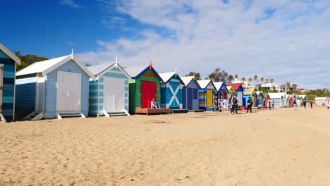 Tourists-walking-and-taking-photo-at-Brighton-Bathing-Boxes,-Melbourne,-Australia