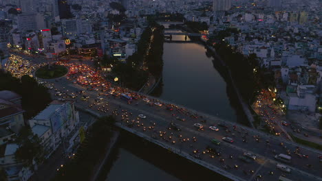 Evening-sunset-slow-tracking-drone-shot-from-left-to-right-looking-down-on-Dien-Bien-Phu-Bridge-and-the-Hoang-Sa-canal-area-of-Binh-Thanh-district,-Saigon-or-Ho-Chi-Minh-City,-Vietnam