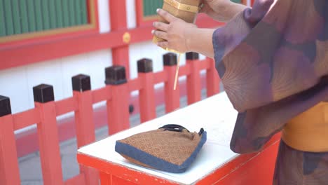 Guy-in-yukata-pulling-out-a-fortune-stick-in-Kyoto,-Japan-soft-lighting-slow-motion-4K