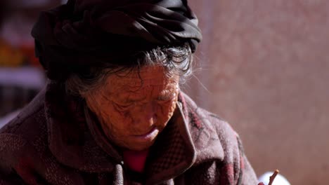 Anciana-Tibetana-En-El-Mercado-De-La-Aldea-De-Shaxizhen-Shaxi-En-La-Mañana-Soleada-Clasificando-Alimentos