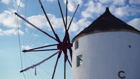 White-windmill-with-a-partly-cloudy-sky-in-the-background,-Santorini,-Greece---Close-up