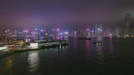 Skyline-Von-Hong-Kong-Island,-Gesehen-Von-Der-Kowloon-Waterfront-Bei-Nacht-Unter-Stimmungsvollem-Himmel