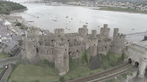 Mittelalterliches-Wahrzeichen,-Historisches-Conwy-Castle,-Luftaufnahme-über-Walisischer-Küstenstadtlandschaft,-Weite-Umlaufbahn-Nach-Links