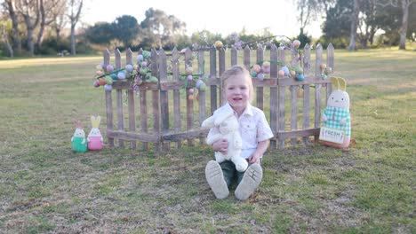 A-young-boy-dressed-for-Easter-smiles-and-holds-his-stuffed-Easter-Bunny